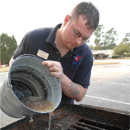 A man pouring waste bucket into a used cooking oil container.