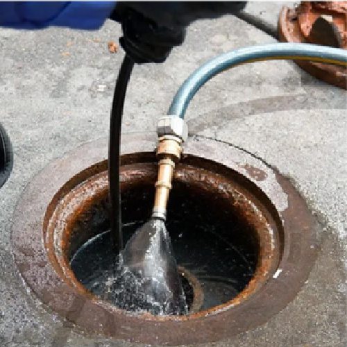 A person is using an air hose to fill up the hole.