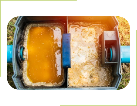 A picture of a grease trap with food waste inside.