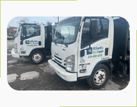 Two Atlantic BioFuels trucks parked in a parking lot.