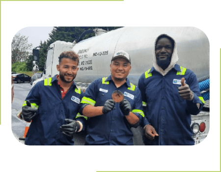 Three Atlantic BioFuels technicians in blue work uniforms posing for a picture.